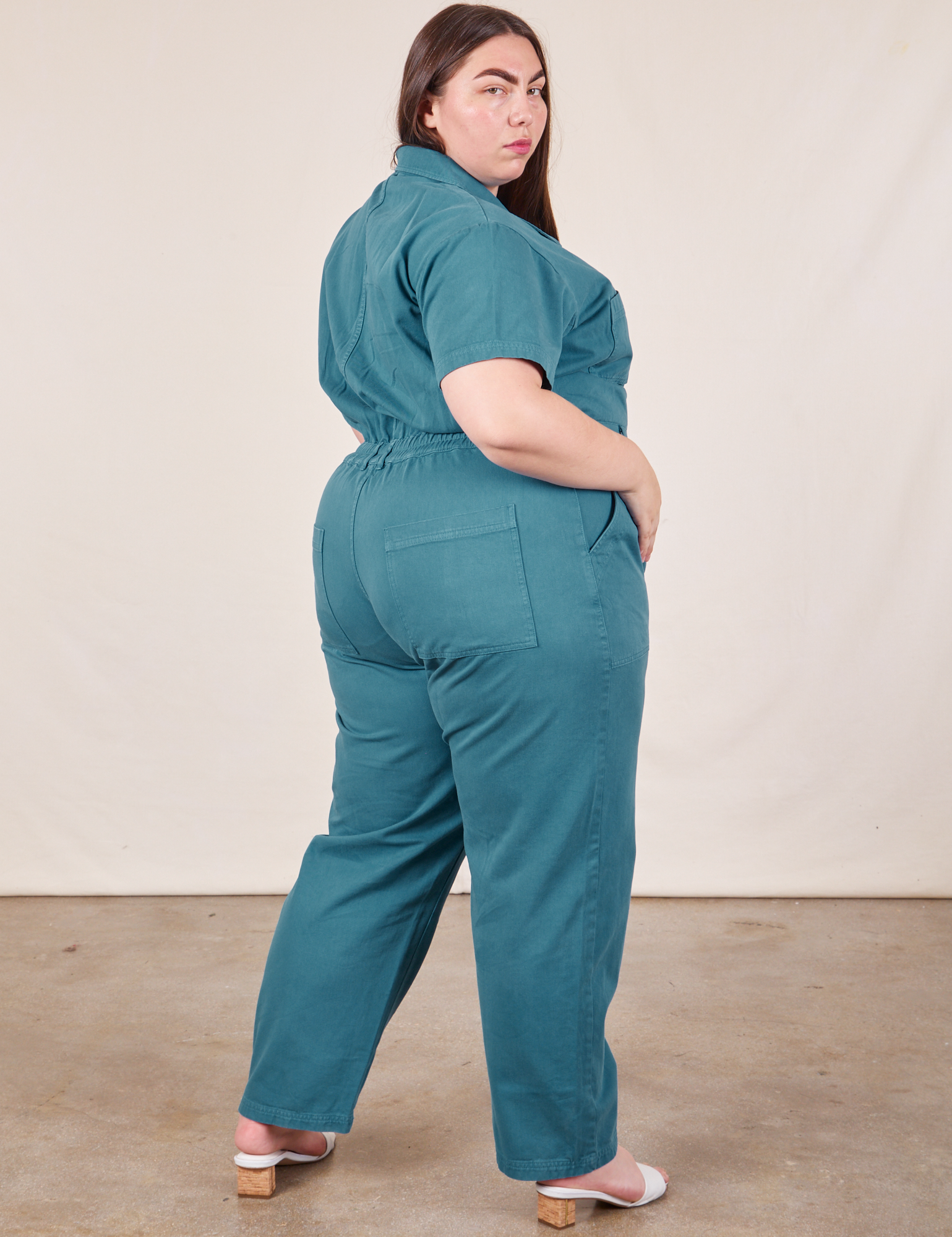 Angled back view of Short Sleeve Jumpsuit in Marine Blue worn by Marielena