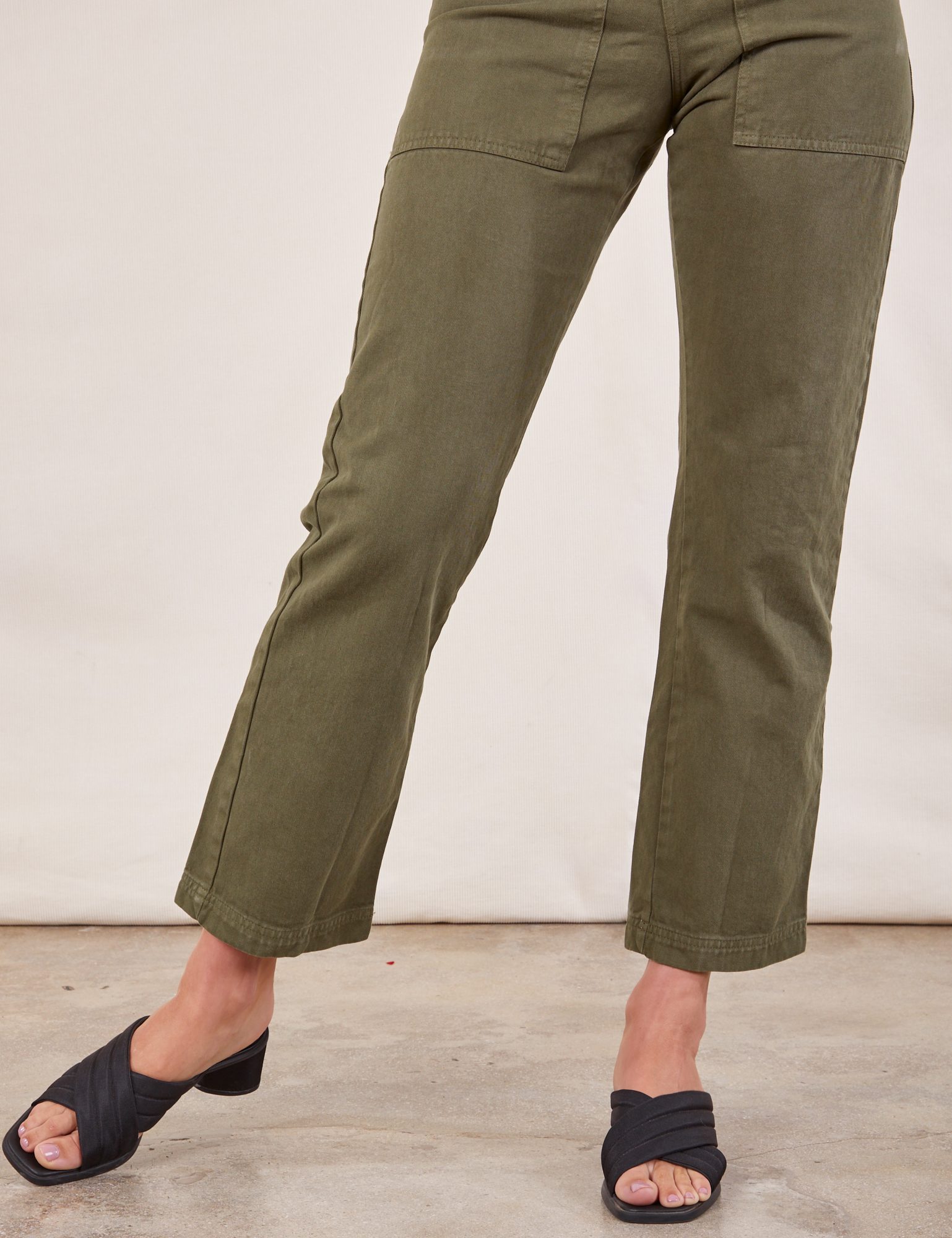 Short Sleeve Jumpsuit in Surplus Green front pant leg close up on Alex