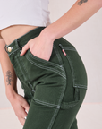 Close up of Alex's hand in the pocket of Carpenter Jeans in Swamp Green