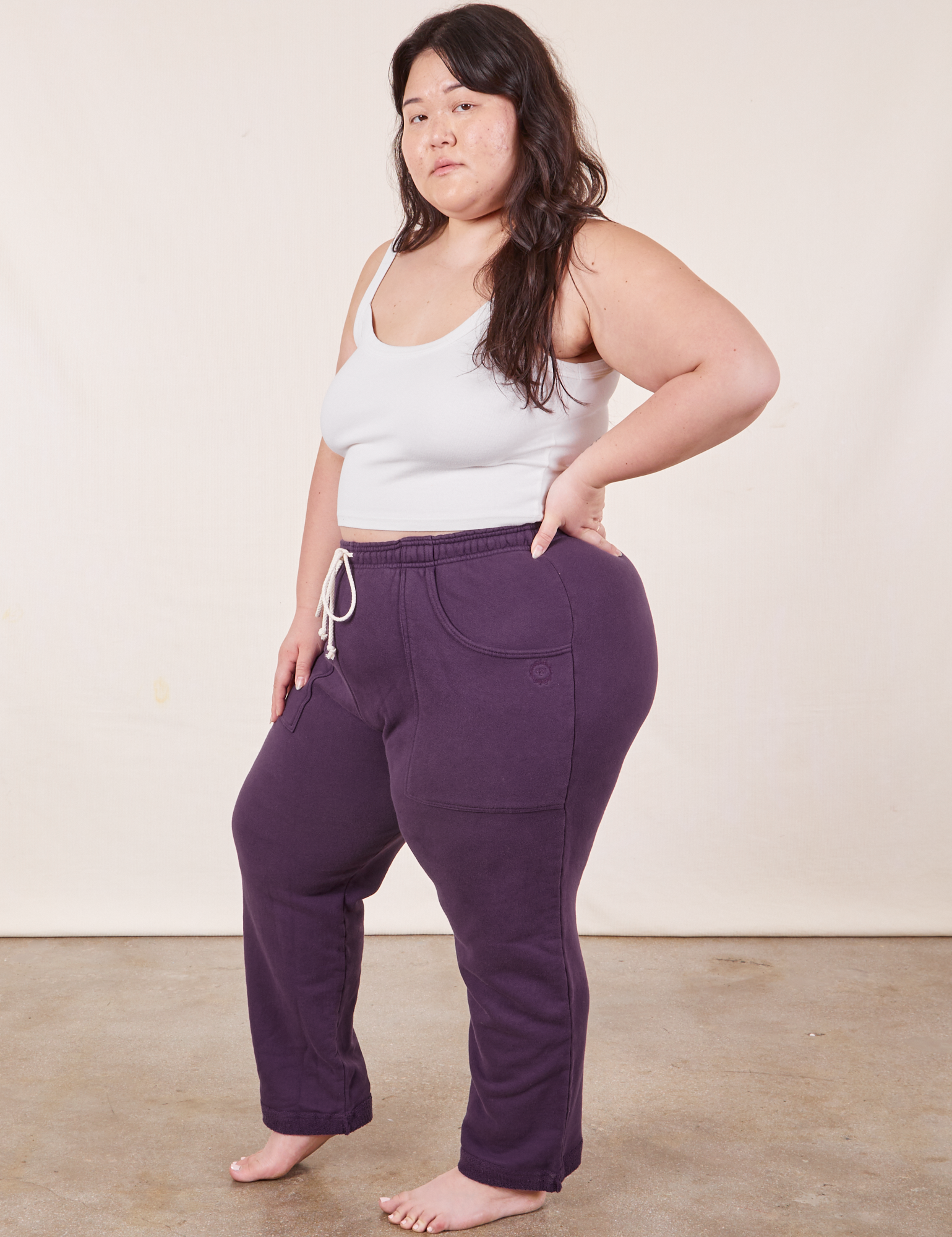 Angled view of Cropped Rolled Cuff Sweatpants in Nebula Purple and vintage off-white Cami on Ashley
