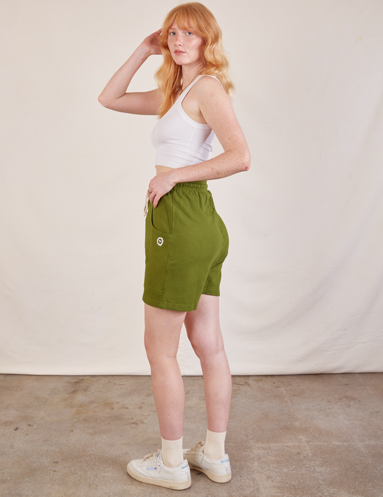 Side view of Lightweight Sweat Shorts in Summer Olive and Cropped Tank in vintage tee off-white on Margaret