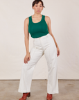 Tiara is 5’4” and wearing XS Tank Top in Hunter Green paired with vintage tee off-white Western Pants