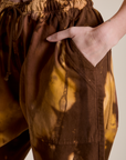 Close up of Alex's hand in the front pocket of Magic Waters Drop Pocket Pants in Honey Brown