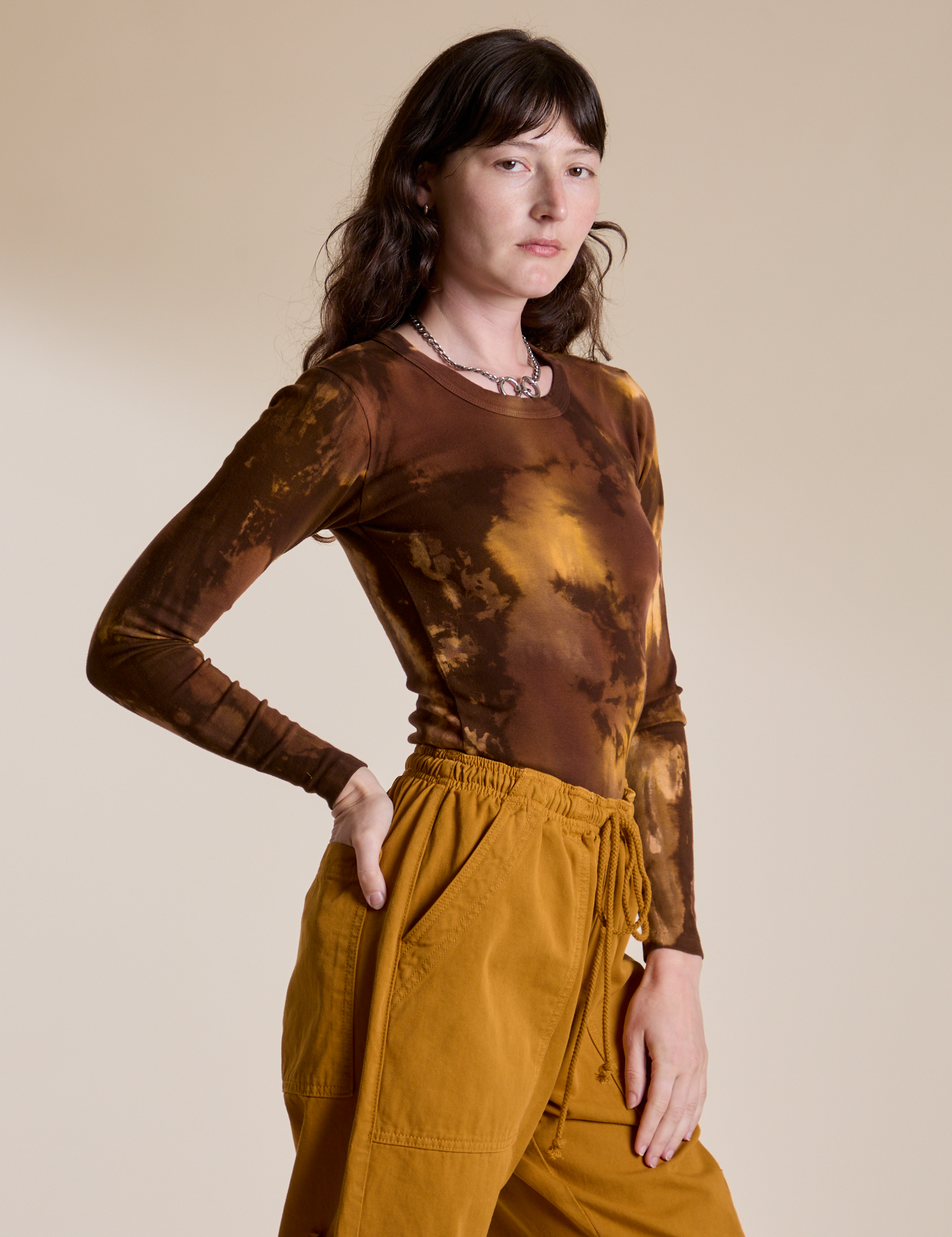 Angled front view of Long Sleeve Baby Tee in Honey Brown on Alex