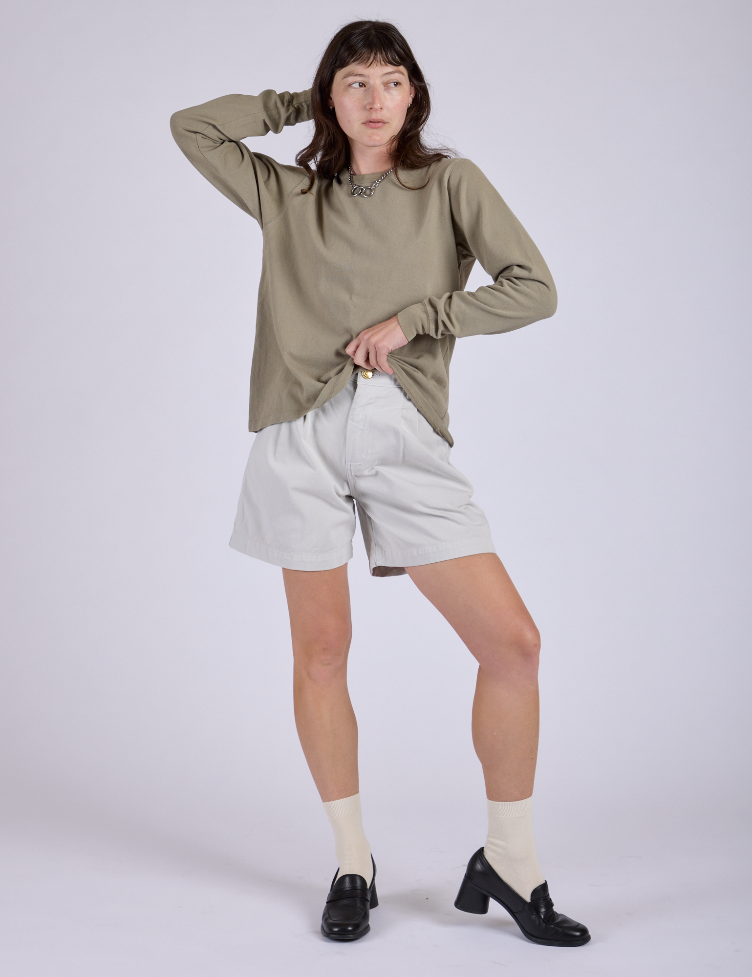 Alex is wearing Pleated Trouser Shorts in Dishwater White and khaki grey Long Sleeve Burly Tee