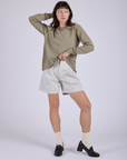 Alex is wearing Pleated Trouser Shorts in Dishwater White and khaki grey Long Sleeve Burly Tee