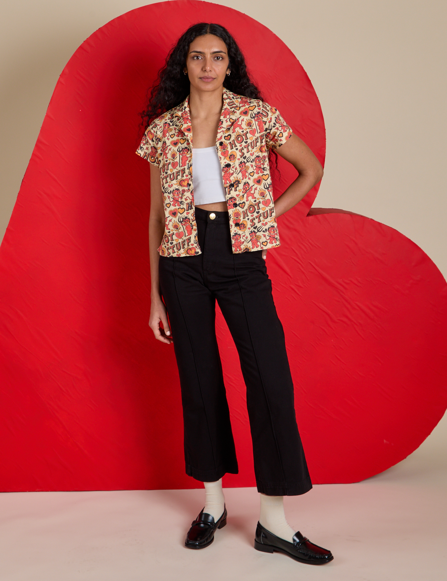 Shahana is wearing Hot Stuff Print Pantry Button-Up paired with black Western Pants