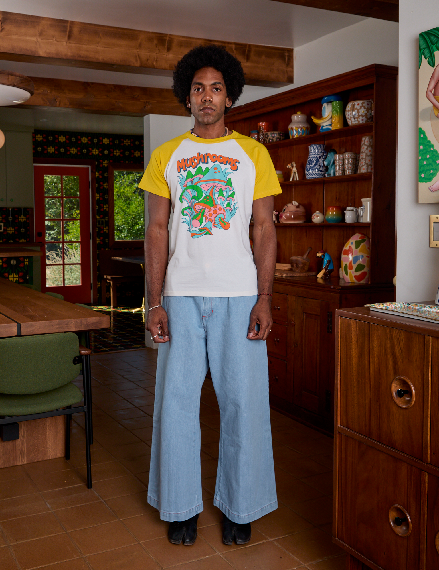 Jerrod is wearing Short Sleeve Raglan Tee in Mushrooms paired with light wash Indigo Wide Leg Trousers