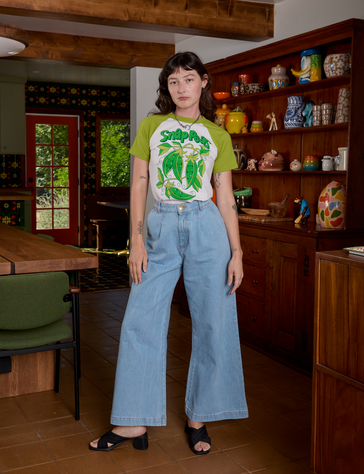 Alex is wearing Short Sleeve Raglan Tee in Snap Peas tucked in to light wash Indigo Wide Trousers