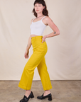 Side view of Western Pants in Golden Yellow and Cropped Cami in vintage tee off-white worn by Alex