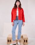 Alex is wearing Denim Work Jacket in Mustang Red paired with light wash Carpenter Jeans