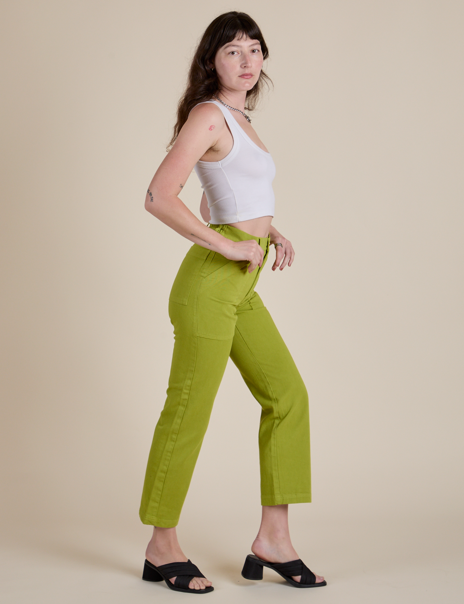Side view of Work Pants in Gross Green and Cropped Tank in Vintage Tee White