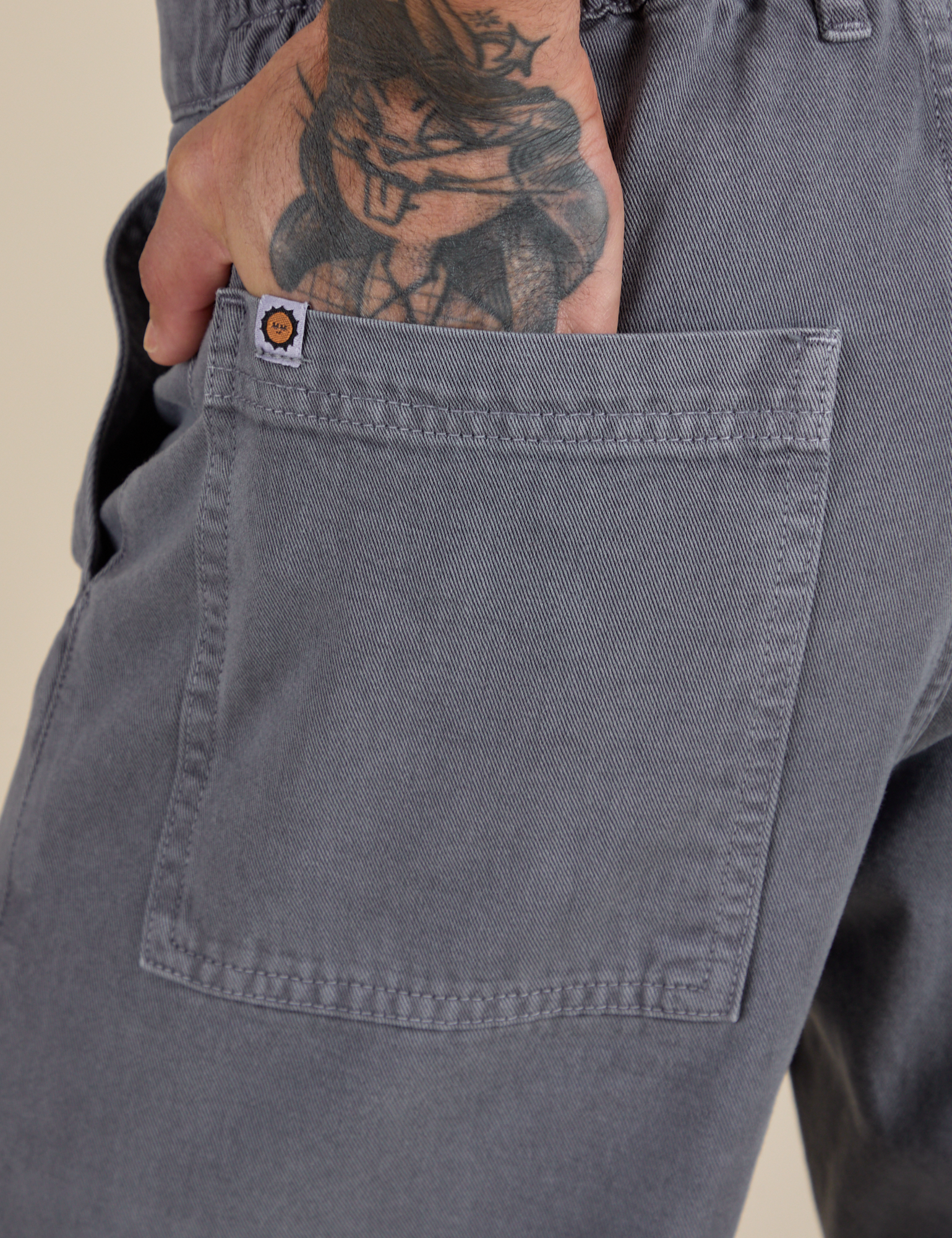 Close up of Jesse's hand in the back pocket of Work Pants in Washed Grey