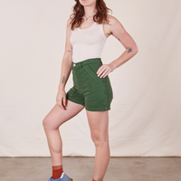 Angled view of Classic Work Shorts in Dark Emerald Green and vintage off-white Tank Top worn by Alex