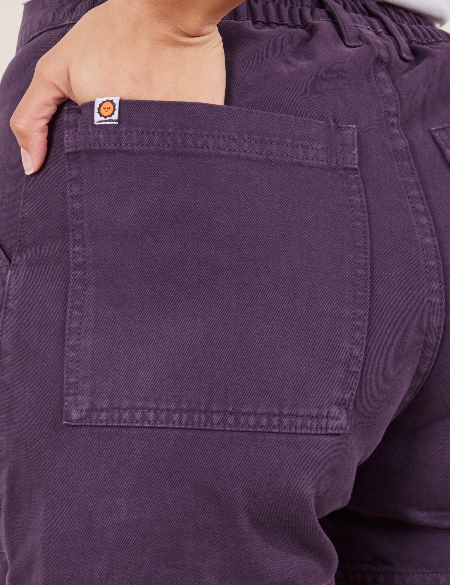Classic Work Shorts in Nebula Purple back pocket close up. Tiara has her hand in the pocket.