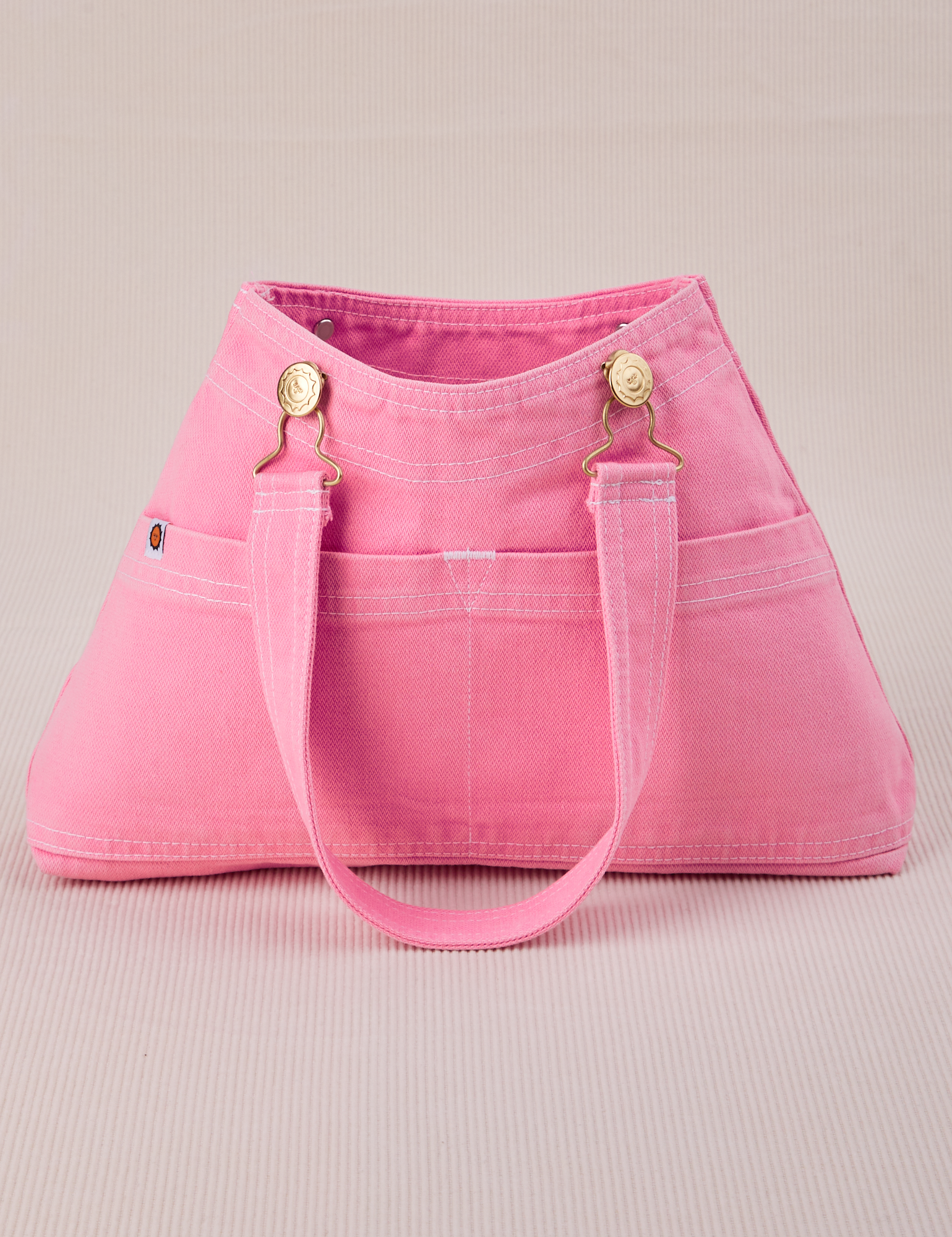 Overall Handbag in Bubblegum Pink with strap laying across front
