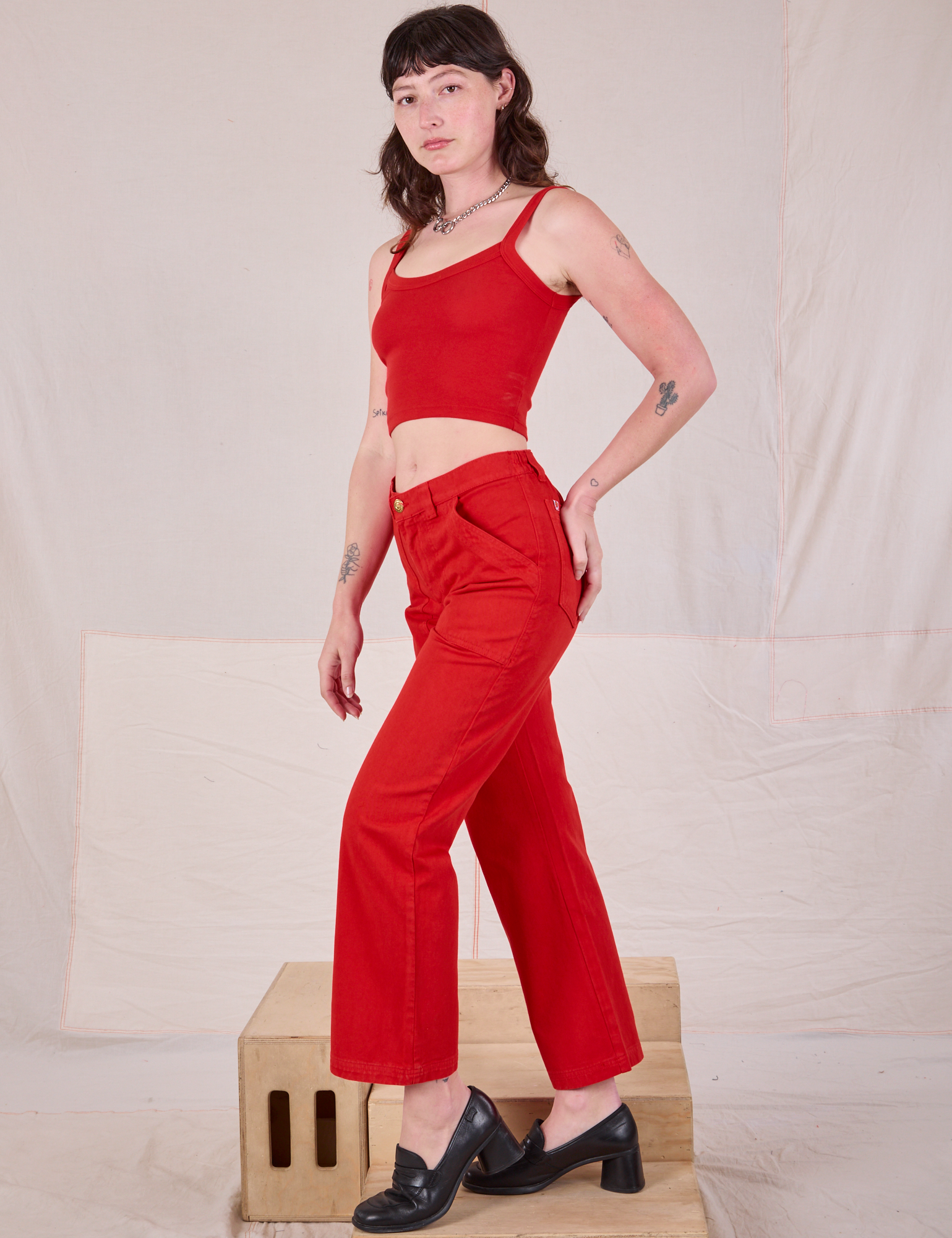 Side view of Mid-Rise Work Pants in Mustang Red and Cropped Cami on Alex