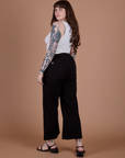 Angled back view of Action Pants in Basic Black and Cropped Tank in Vintage Tee White on Sydney