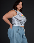 Angled side view of the Dark Cloud Airbrush Muscle Tee and Light Wash Denim Drop Pocket Pants on Kristen