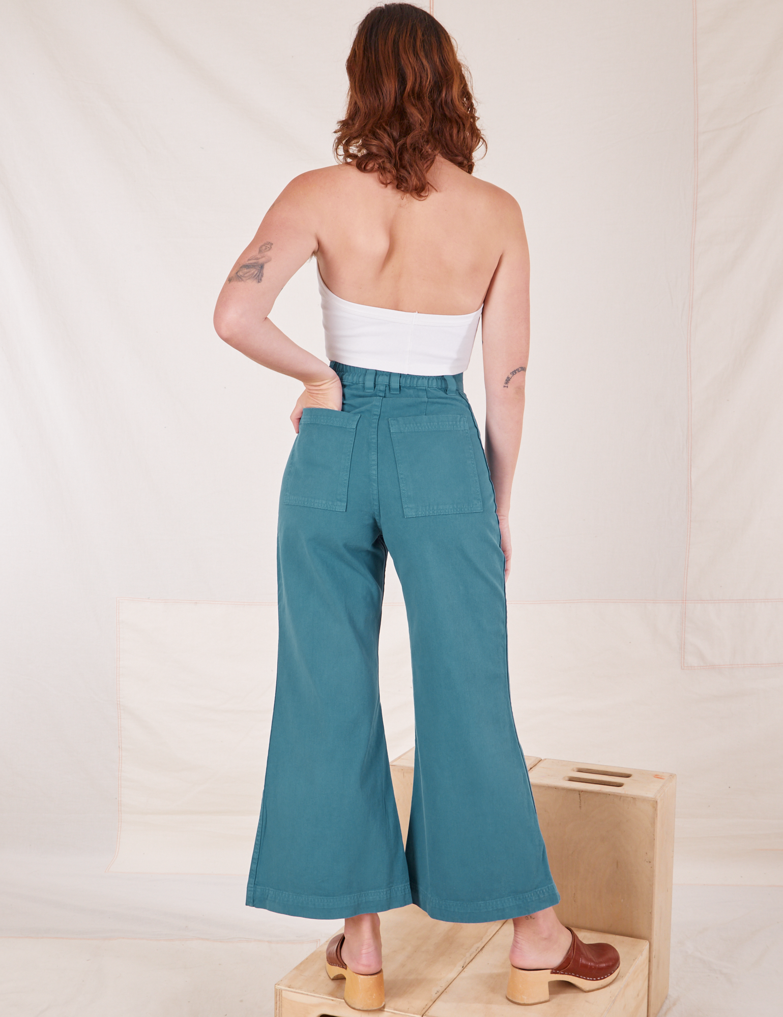 Back view of Bell Bottoms in Marine Blue and vintage off-white Halter Top on Alex