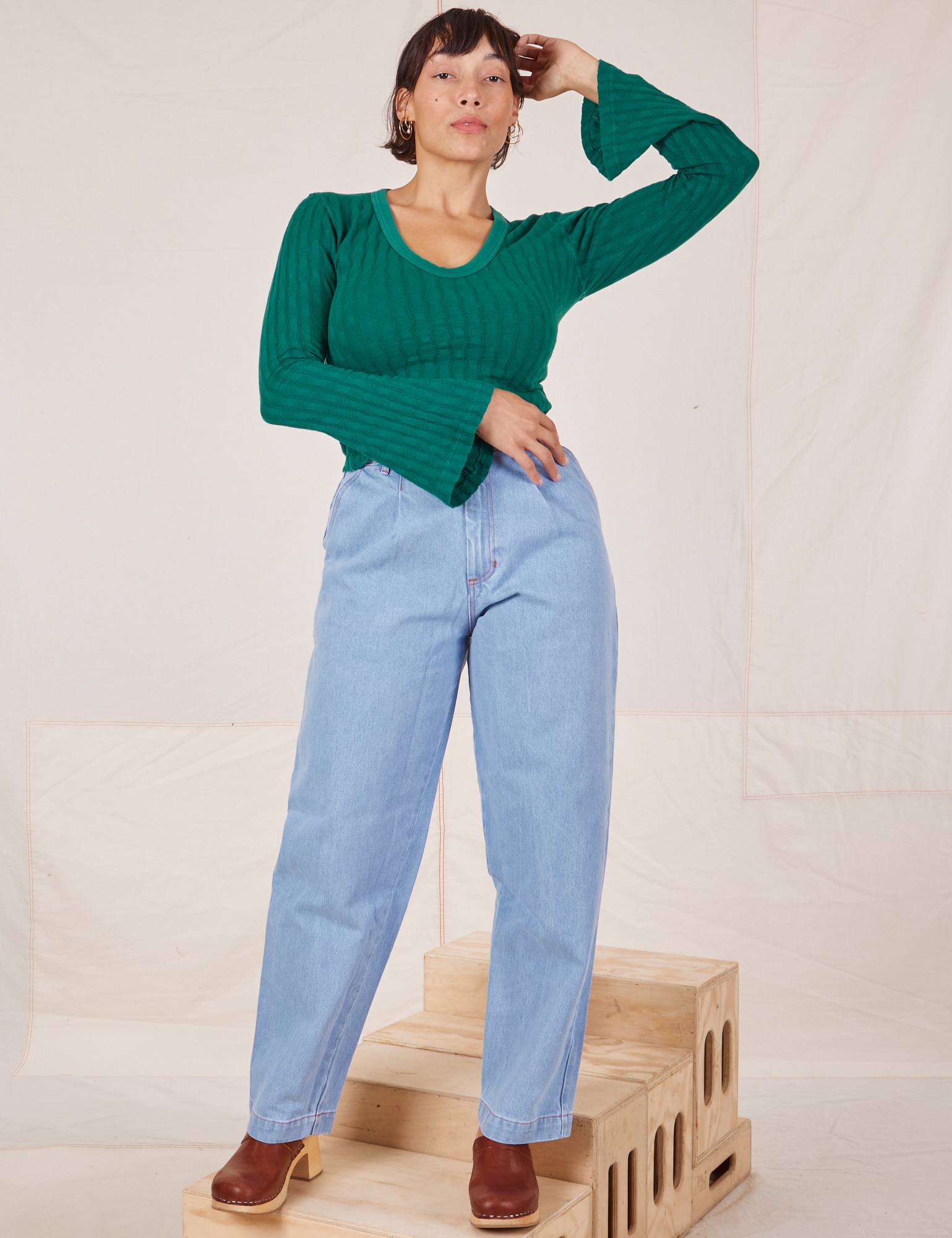 Tiara is wearing S Bell Sleeve Top in Hunter Green paired with light wash Trouser Jeans