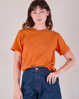 Alex is wearing Burly Tee in Construction Orange tucked into dark wash Denim Wide Leg Trousers