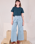 Alex is wearing Burly Tee in Lagoon and light wash Denim Wide Leg Trousers