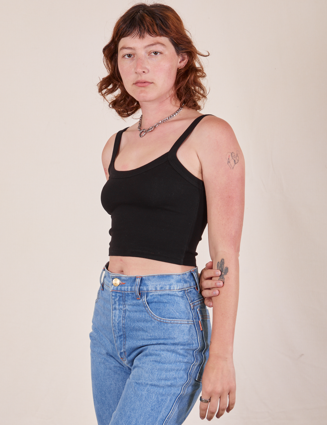 Angled view of Cropped Cami in Basic Black and light wash Frontier Jeans worn by Alex