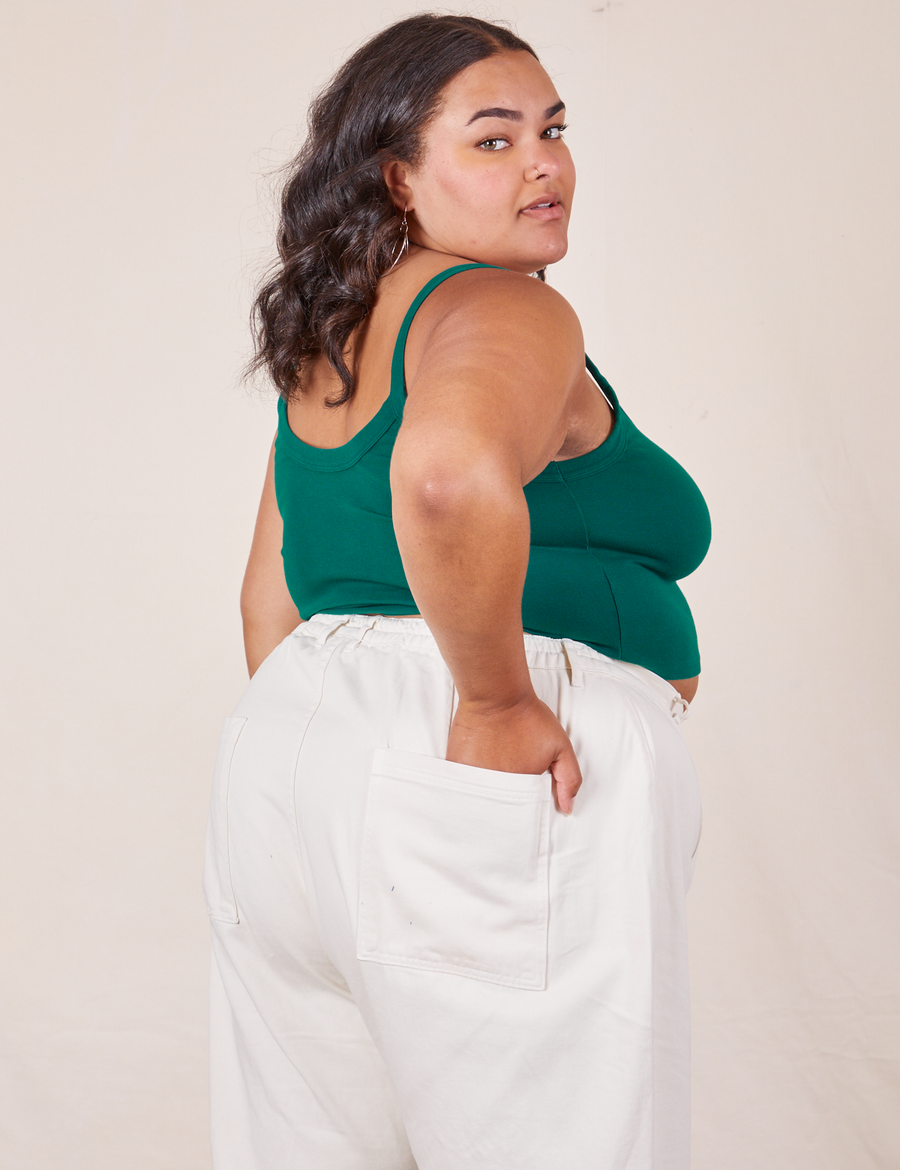 Angled back view of Cropped Cami in Hunter Green and vintage off-white Western Pants worn by Alicia.