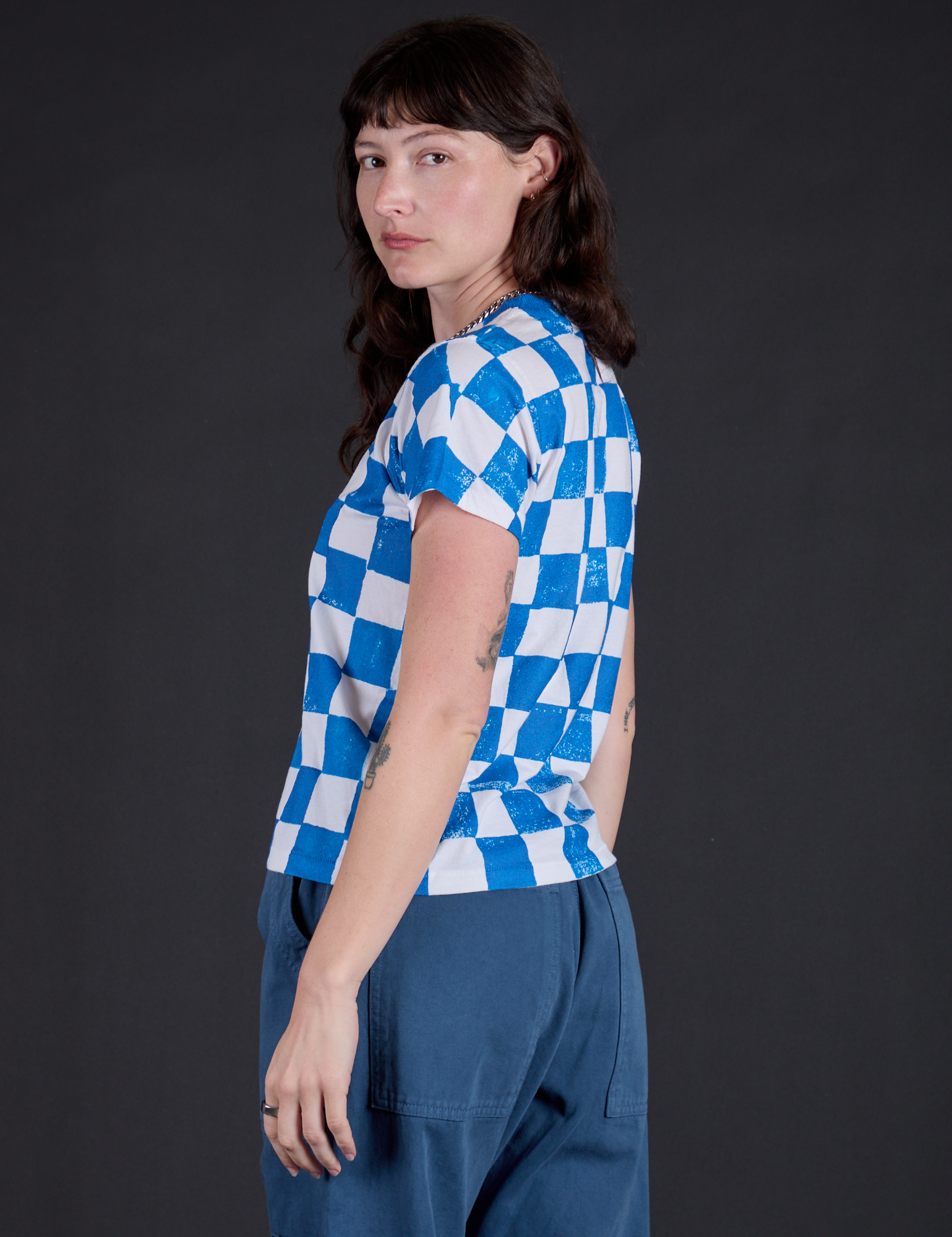Angled back view of Checker Organic Tee in Blue on Alex