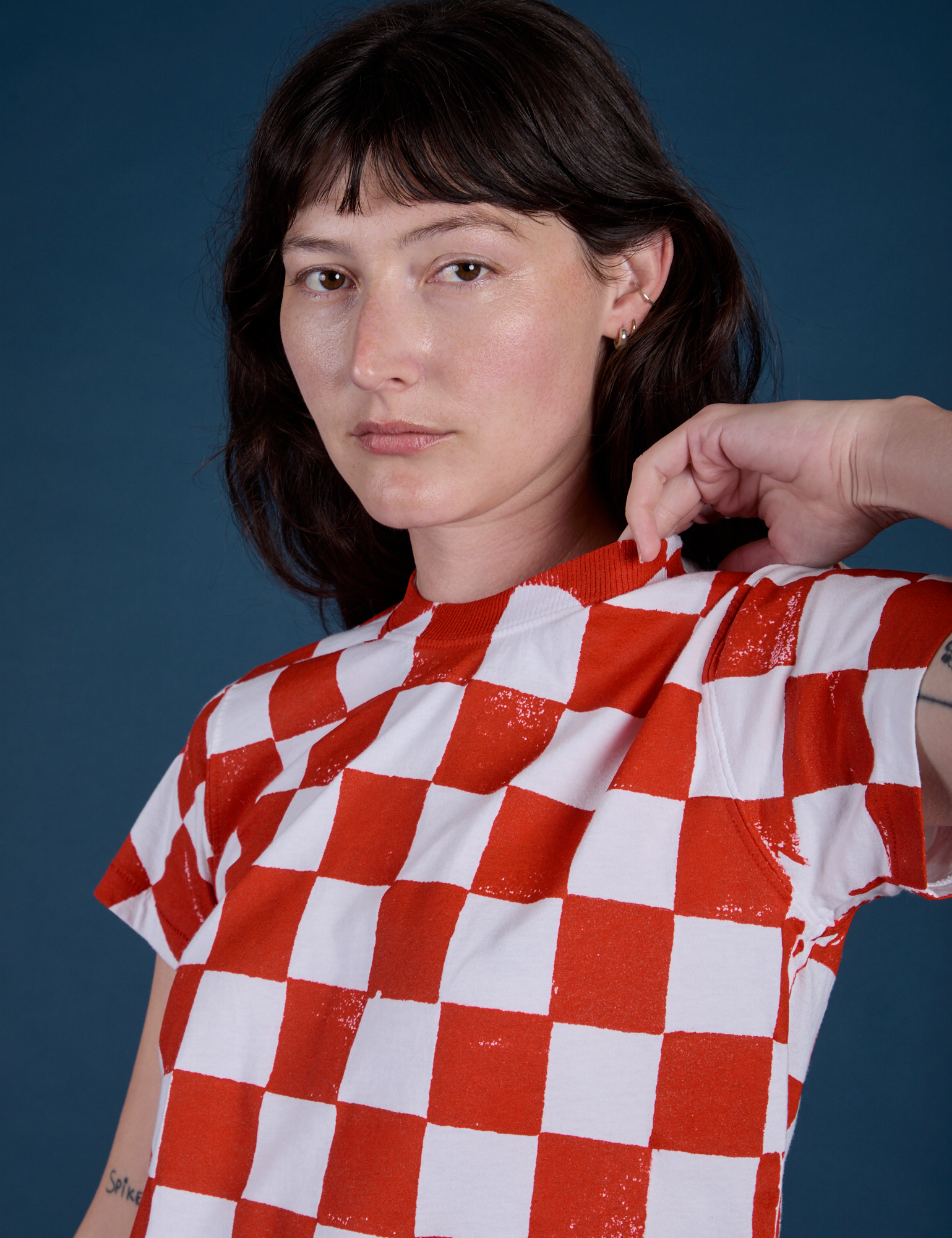 Angled front view close up of Checker Organic Tee in Red on Alex