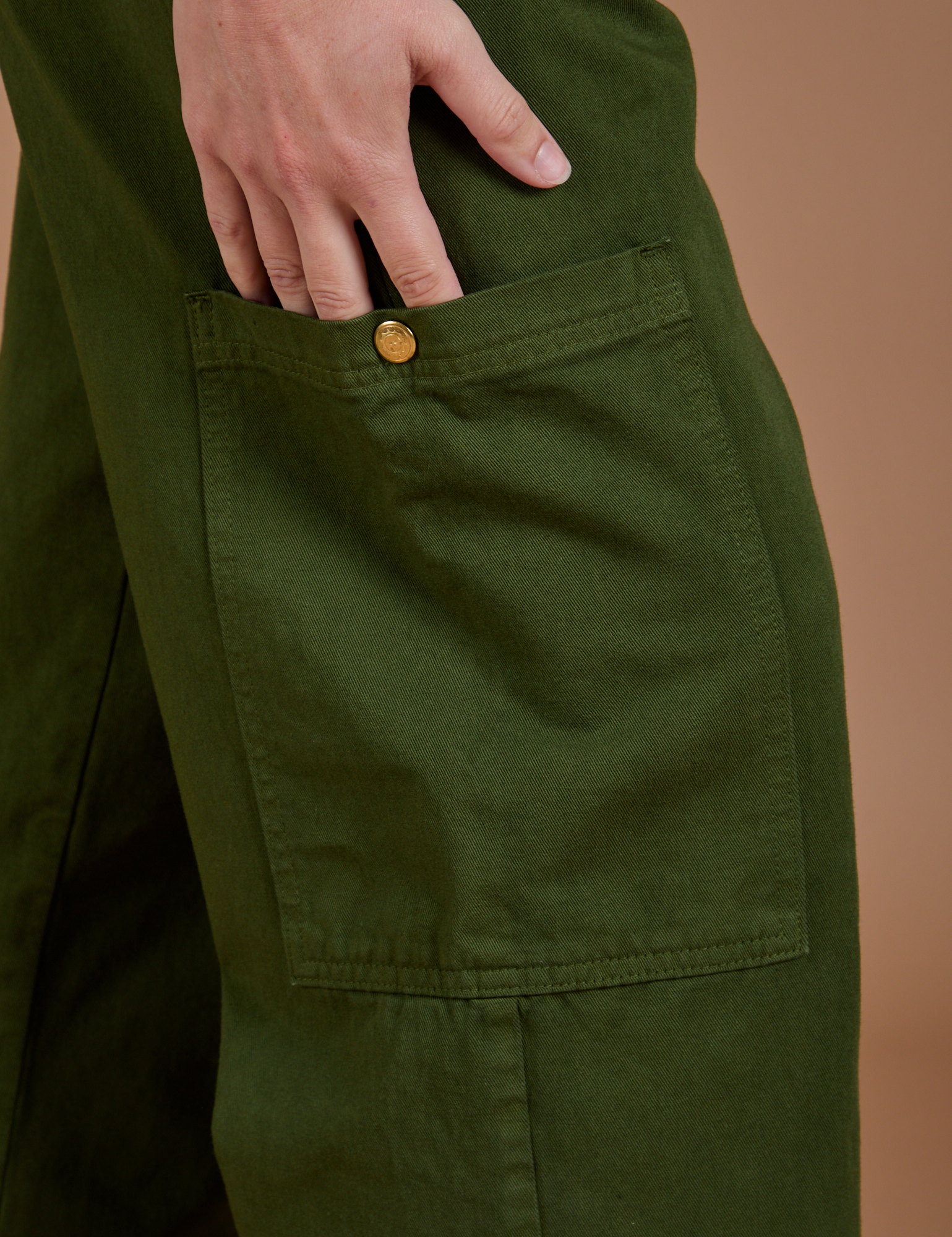 Close up of side leg pant pocket with Alex&#39;s hand tucked in