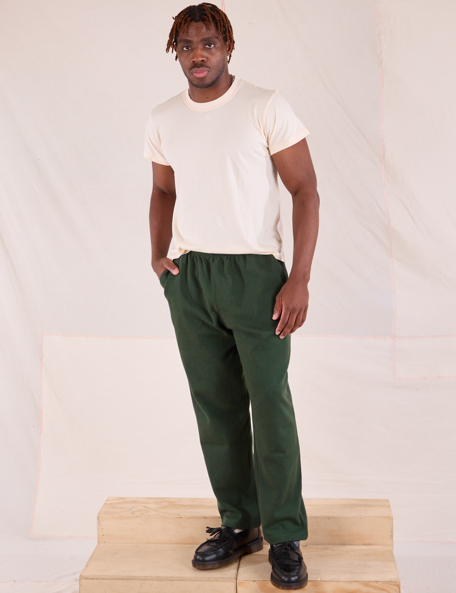 Issac is wearing Easy Pants in Swamp Green and Organic Vintage Tee in Vintage Tee Off-White