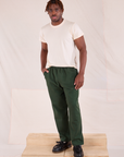 Issac is wearing Easy Pants in Swamp Green and Organic Vintage Tee in Vintage Tee Off-White