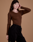 Angled front view of Gingham Long Sleeve Baby Tee in Fudgesicle Brown on Alex