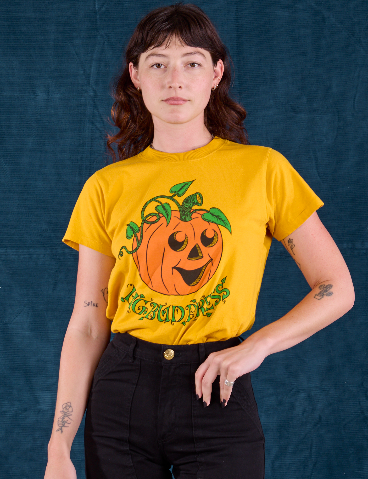 Alex is wearing the Halloween Organic Tee in Pumpkin tucked into black Work Pants