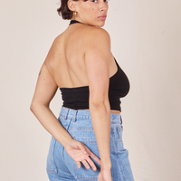 Back view of Halter Top in Basic Black and light wash Frontier Jeans worn by Tiara