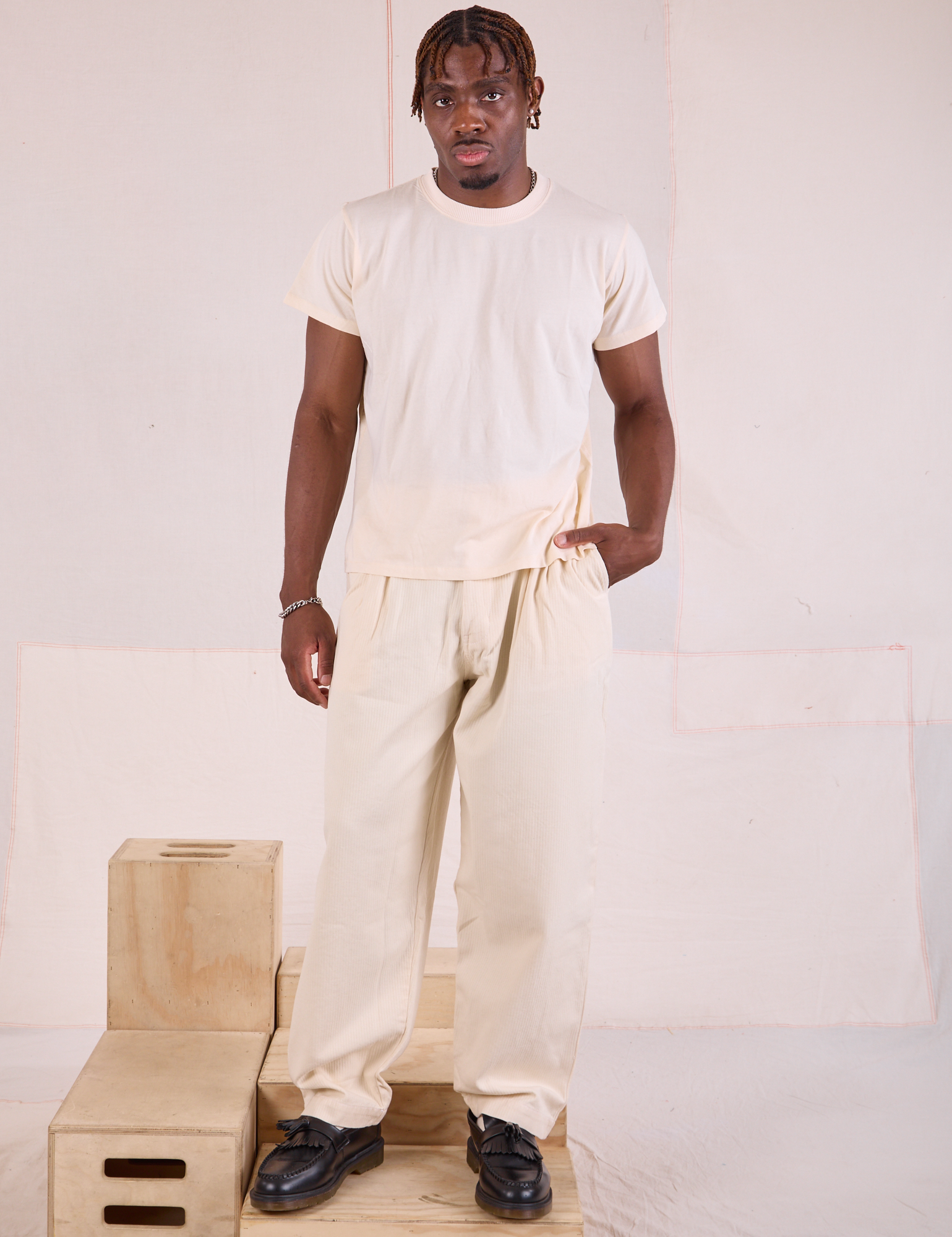 Issac 5’10” is and wearing M Heritage Trousers in Natural paired with Organic Vintage Tee in vintage tee off-white