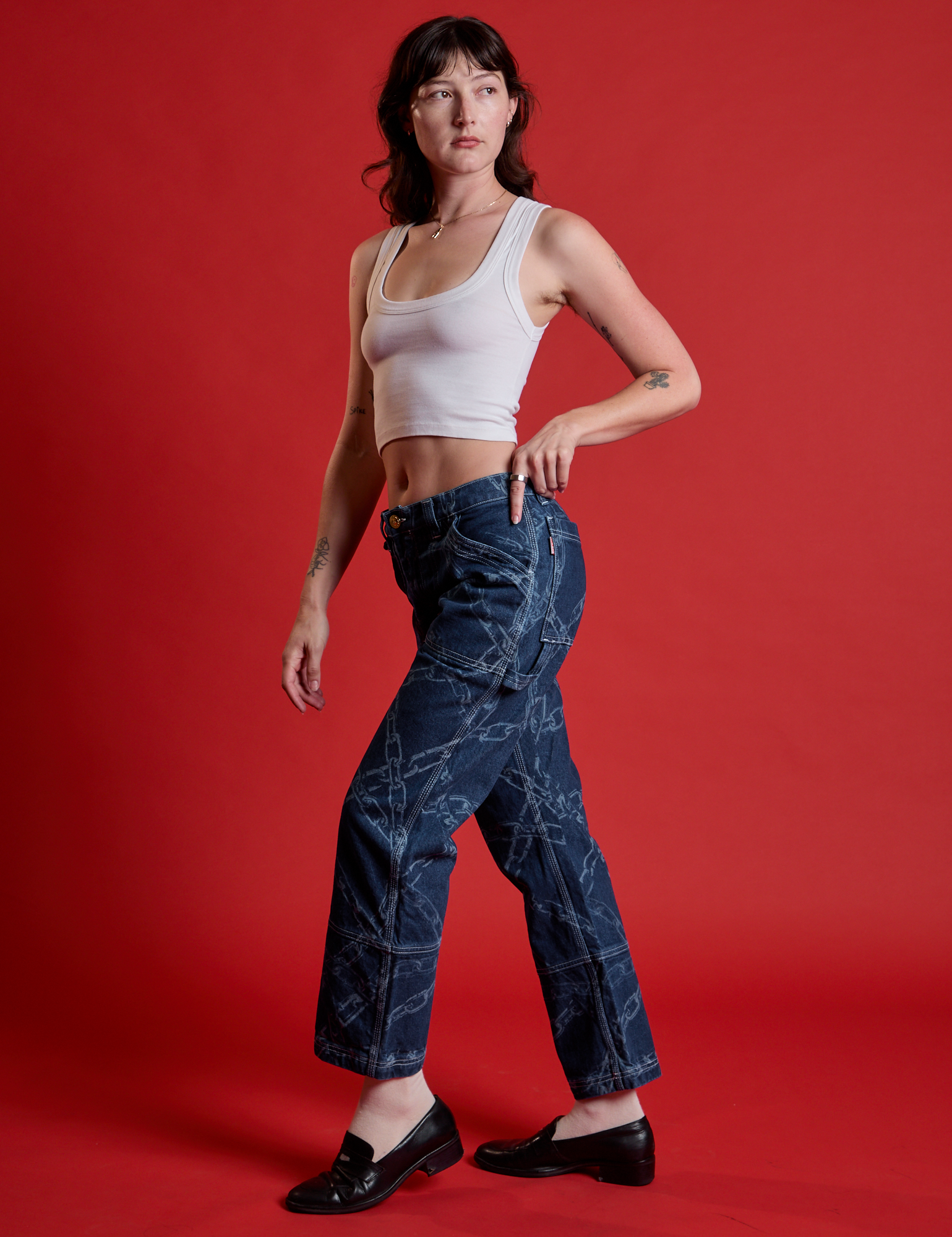 Side view of Mid-Rise Carpenter Jeans in Chain Link and Cropped Tank in Vintage Tee White on Alex