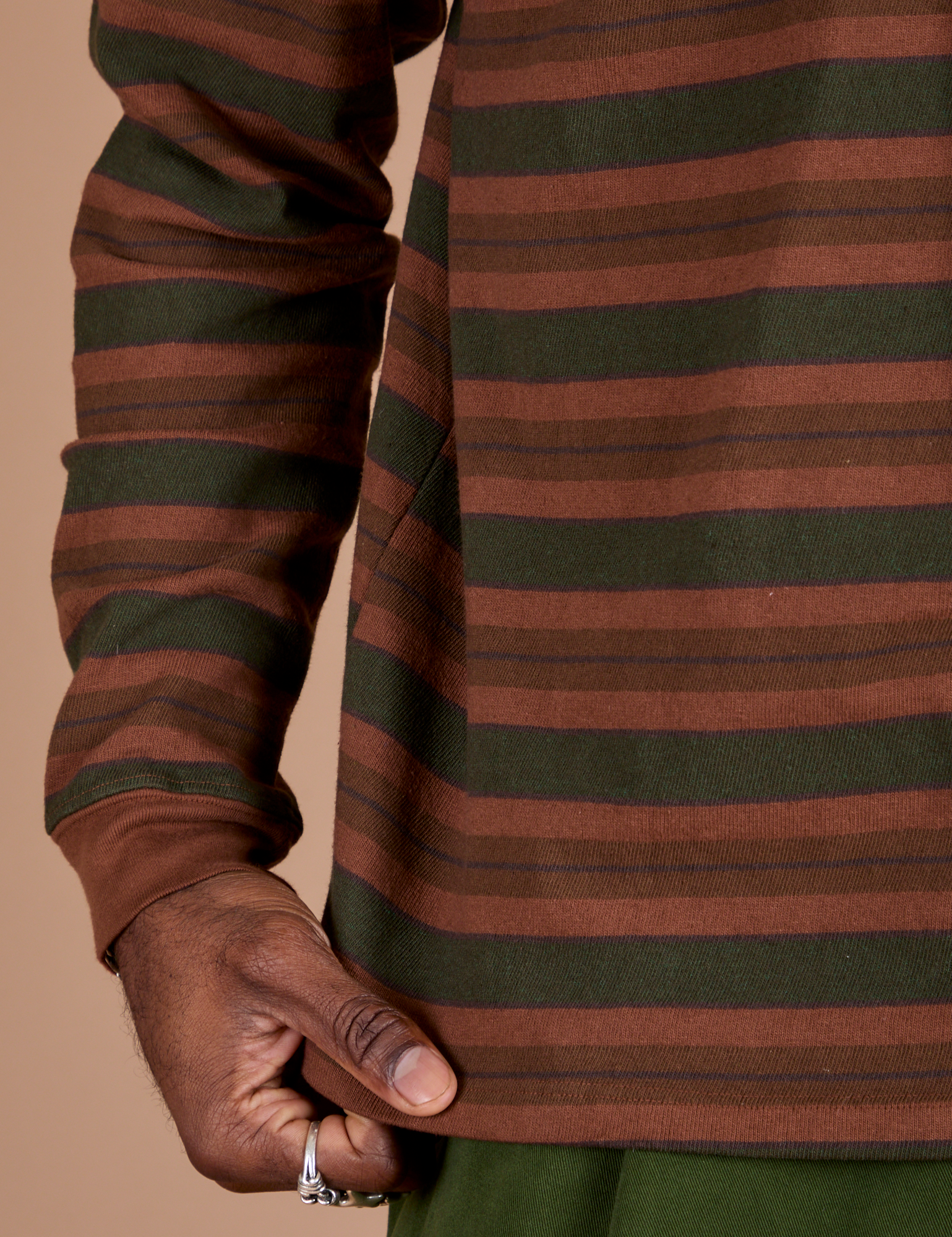 Long Sleeve Striped Burly Tee in Fudgesicle bottom close up with Jerrod holding the hem