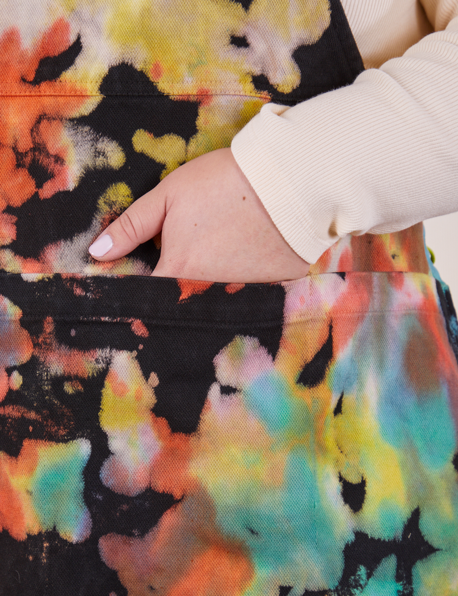 Front pocket close up of Artist Togs Full Apron in Rainbow Magic Waters. Ashley has her hand in the apron pocket.