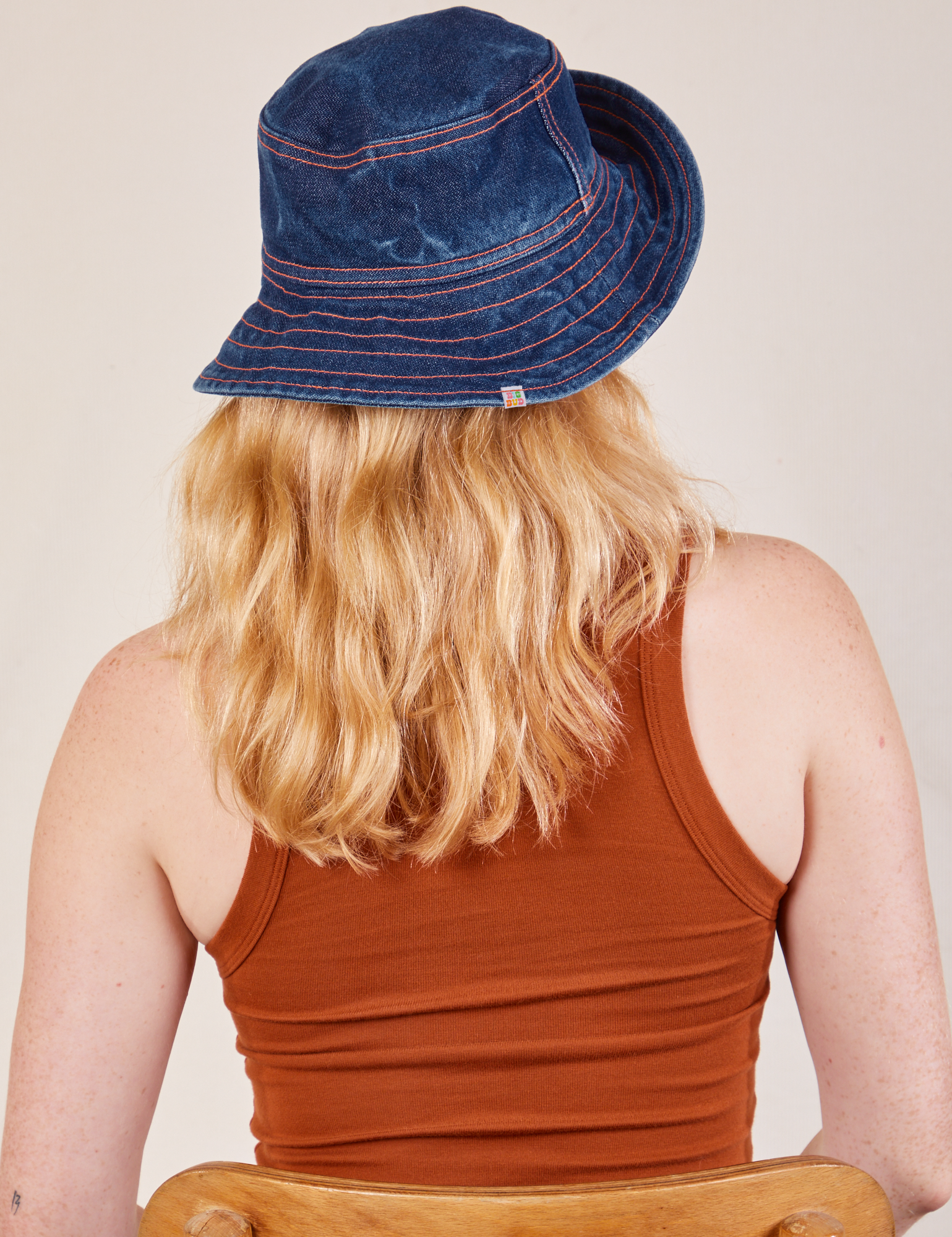 Back view of the Wide Brim Denim Bucket Hat in dark wash worn by Margaret