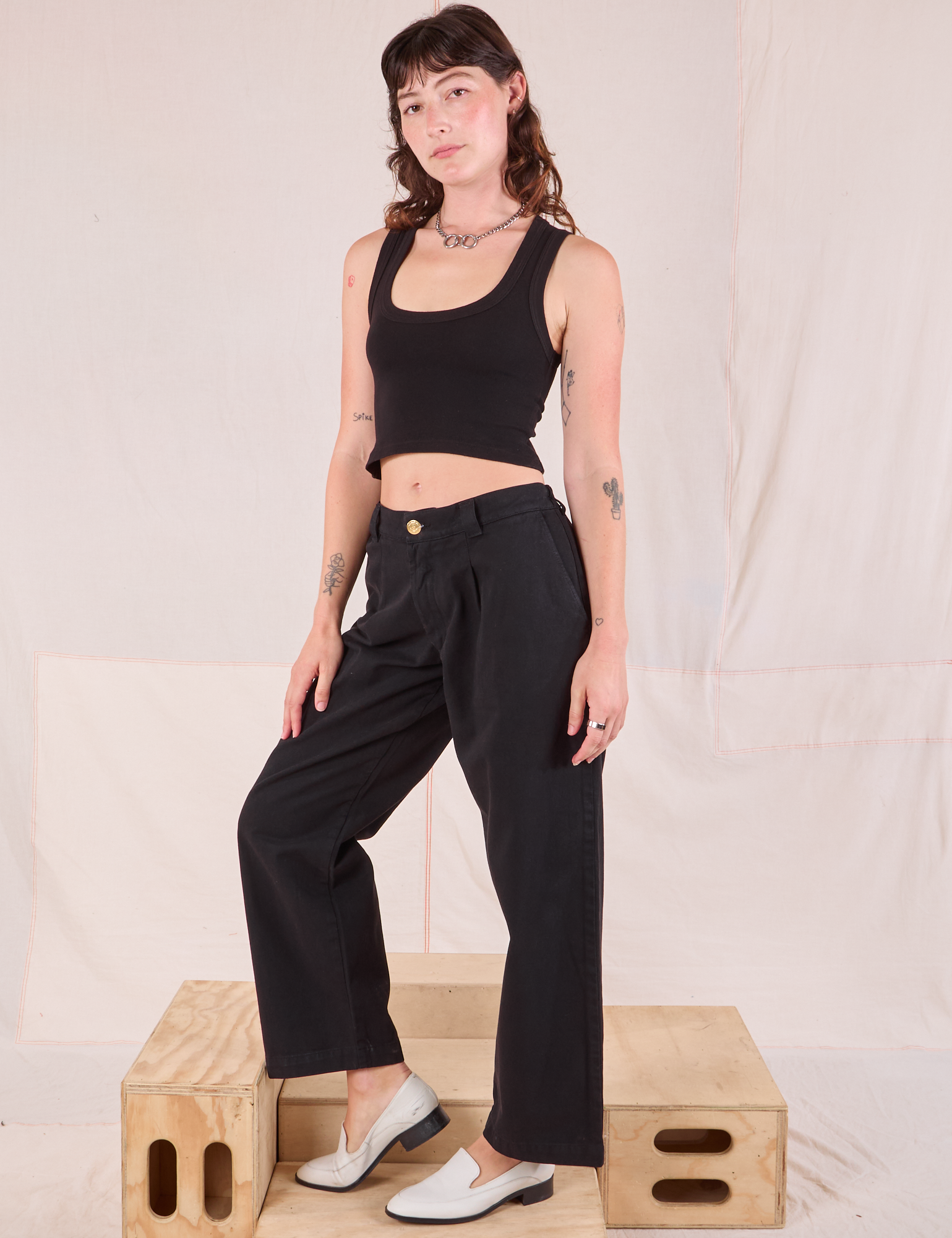 Angled front view of Mid-Rise Pleated Trousers in Basic Black and black Cropped Tank on Alex