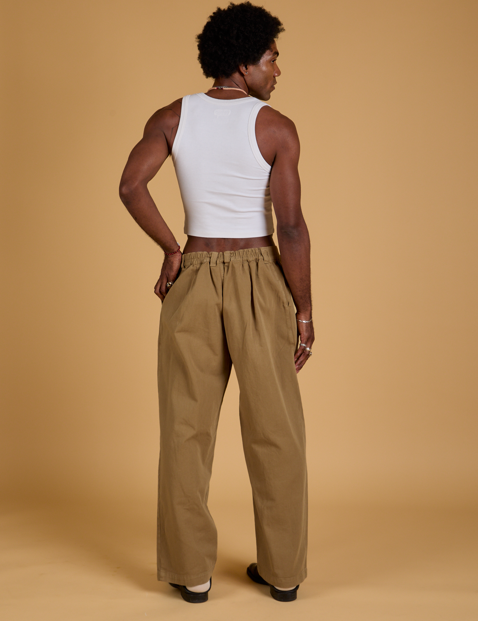 Back view of Baggy Mid-Rise Trousers in Desert Brown and vintage tee white Cropped Tank on Jerrod