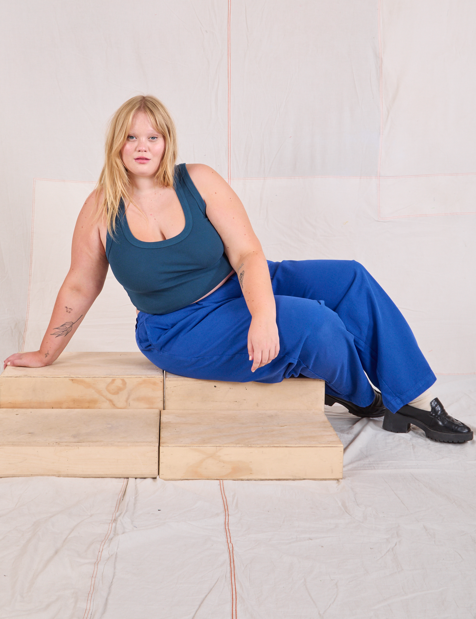 Juliet is wearing Mid-Rise Pleated Trousers in Royal Blue and lagoon Cropped Tank