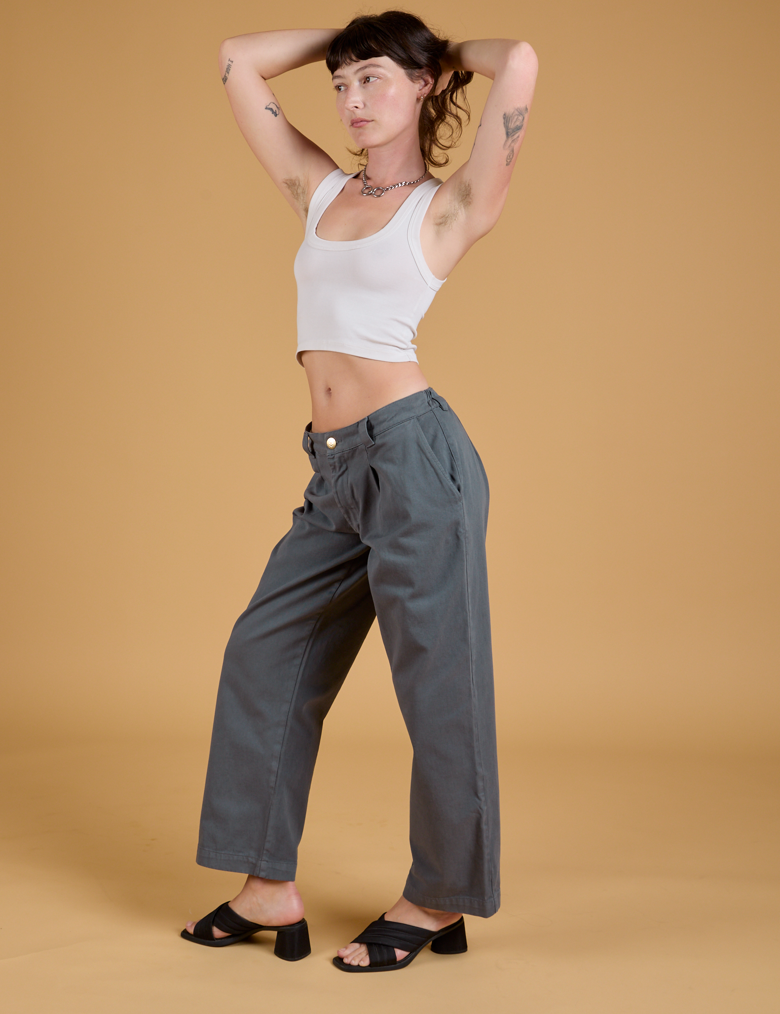 Angled front view of Baggy Mid-Rise Trousers in Slate Grey and vintage tee white Cropped Tank on Alex