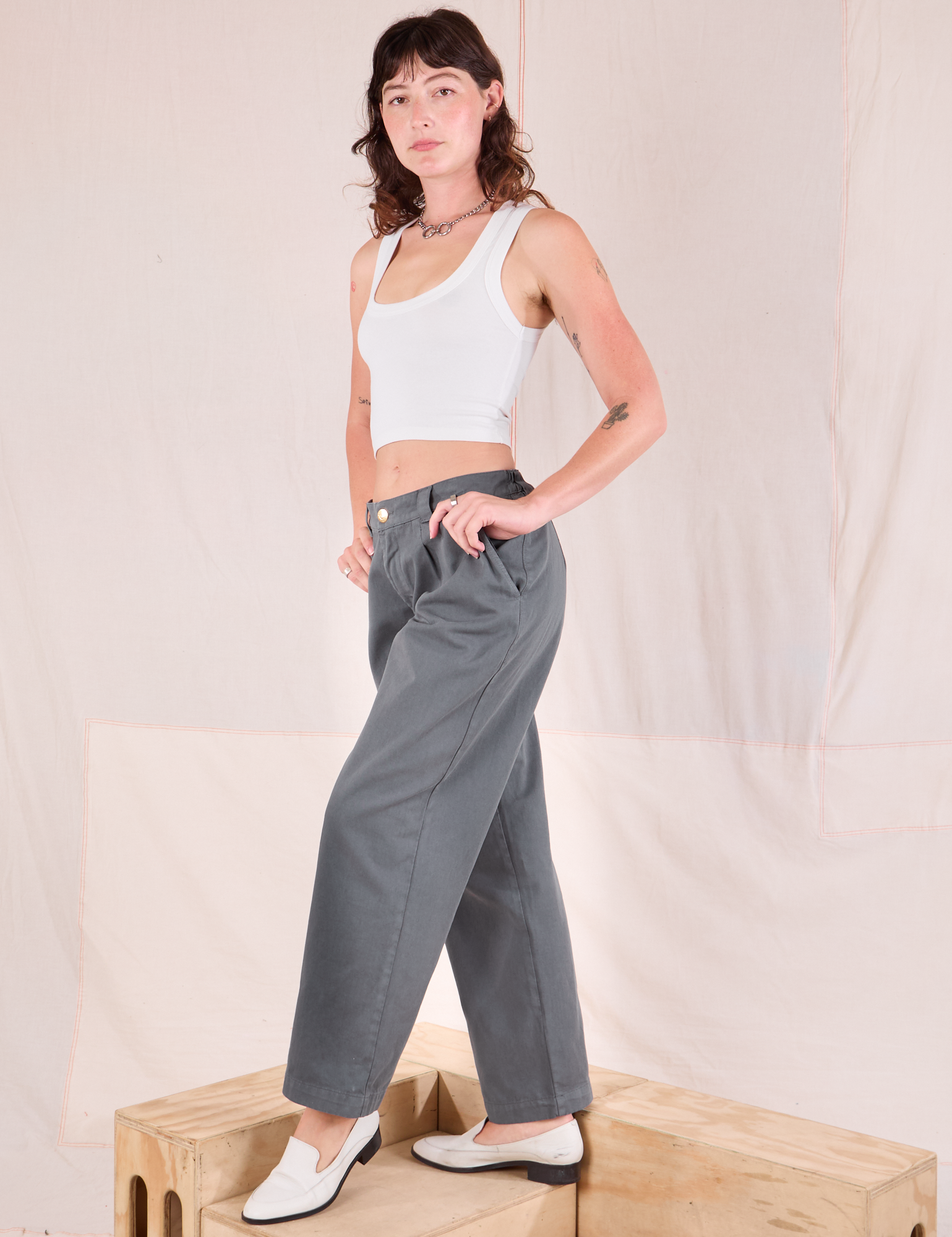 Side view of Mid-Rise Pleated Trousers in Slate Grey and Cropped Tank in vintage tee off-white