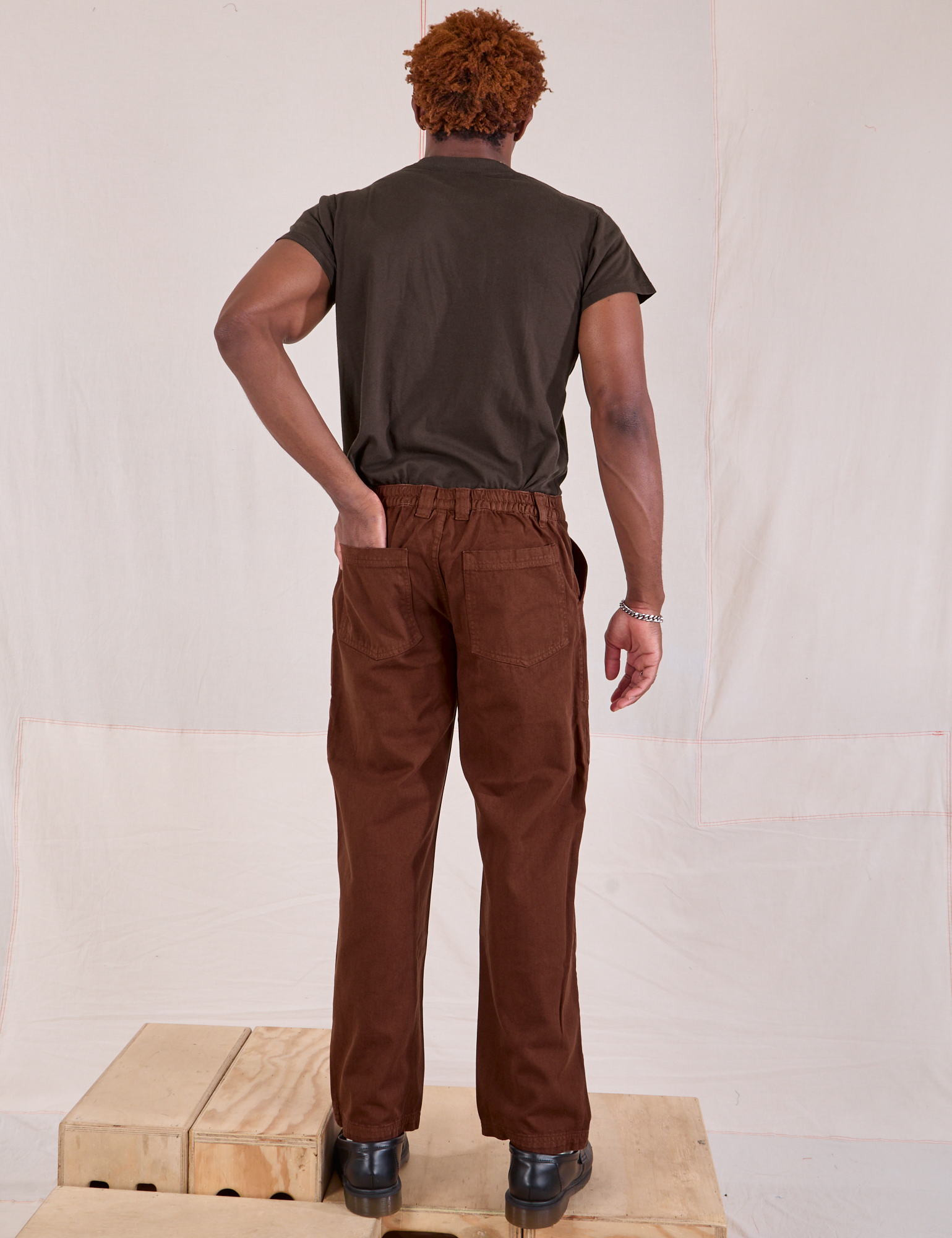 Back view of Mid-Rise Work Pants in Fudgesicle Brown and espresso brown Organic Vintage Tee on Issac