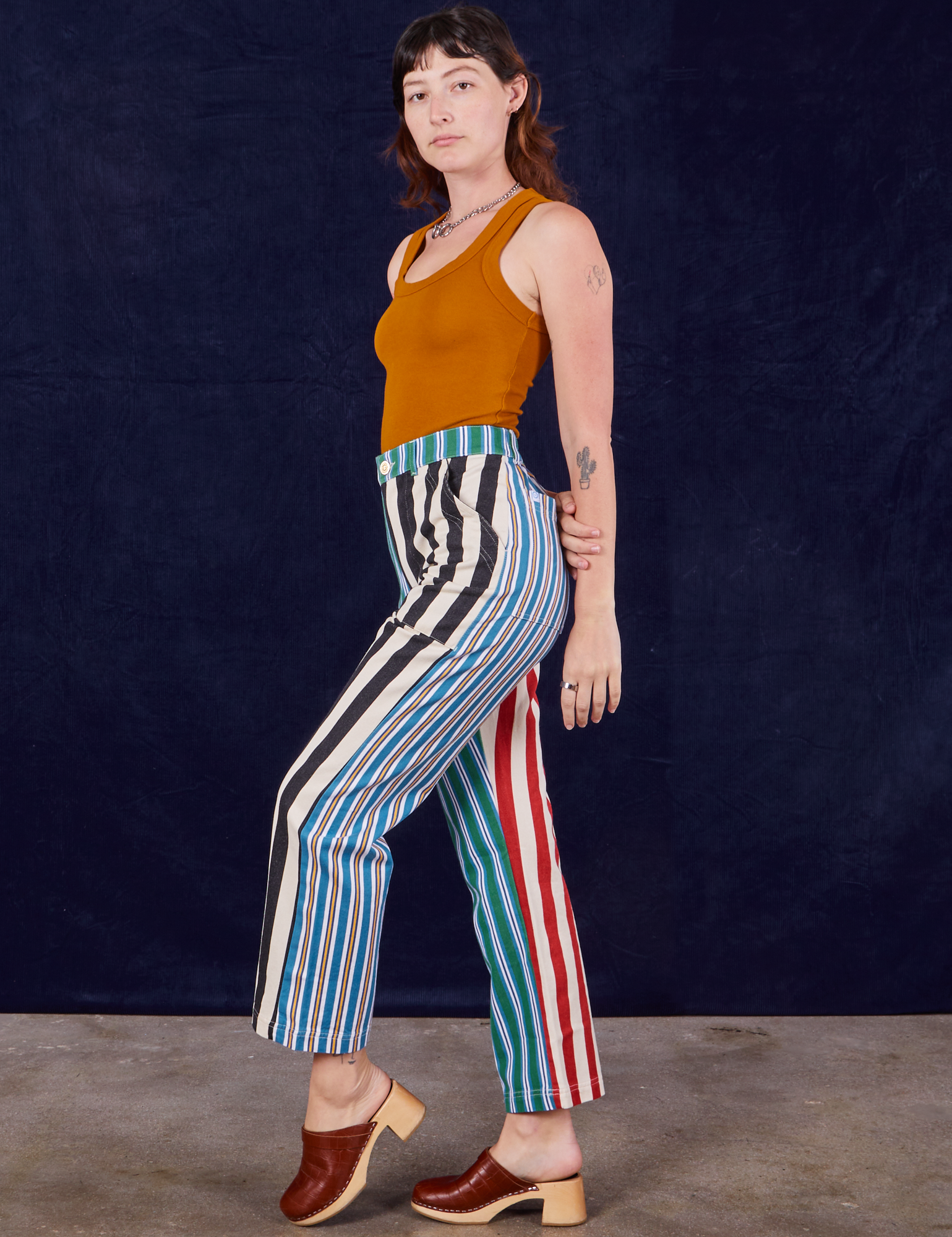 Side view of 4-Way Stripe Work Pants and spicy mustard Tank Top on Alex