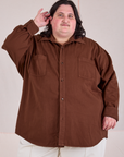 Sam is wearing a buttoned up Twill Overshirt in Fudgesicle Brown